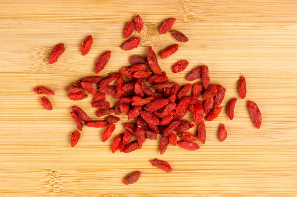 Pile of dry goji berries on a wooden board — Stock Photo, Image