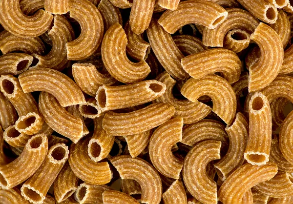 Macro background texture of wholemeal ribbed uncooked raw macaro — Stock Photo, Image