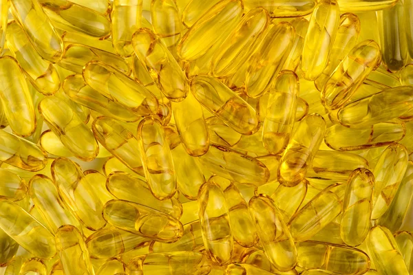 Textura de fondo amarillo de las cápsulas de aceite de pescado con ácidos grasos omega — Foto de Stock