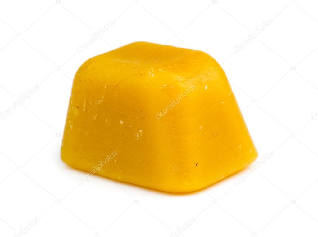 Isolated single cube of beeswax on white background