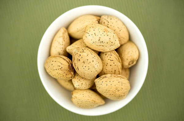 Un-cracked natural almonds in shells in bowl — Stock Photo, Image