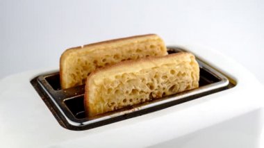 Ağır çekim ekmek tost ve ekmek kızartma makinesi üzerinde beyaz izole dışarı haşhaş olmak hızlandırılmış