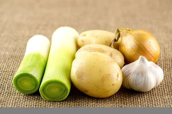 Ajo fresco, patata, puerro y cebolla en saco de arpillera — Foto de Stock