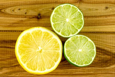 Circular cross-section halves of ripe lemon and limes clipart