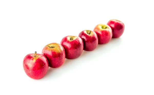 Vibrant red apples arranged in a line against white with copyspa — Stock Photo, Image