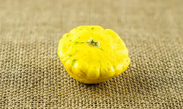 Makro gula knappen sommar squash mot hessian konsistens — Stockfoto
