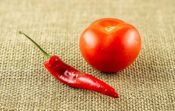 Makro velmi pikantní chilli a červené zralé rajče — Stock fotografie