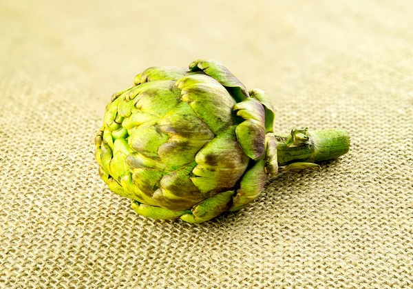 Raw artichoke thistle veggie on hessian — Stock Photo, Image