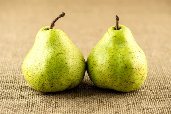 Sappige sappige peren tegen Hessiaan geweven doek — Stockfoto