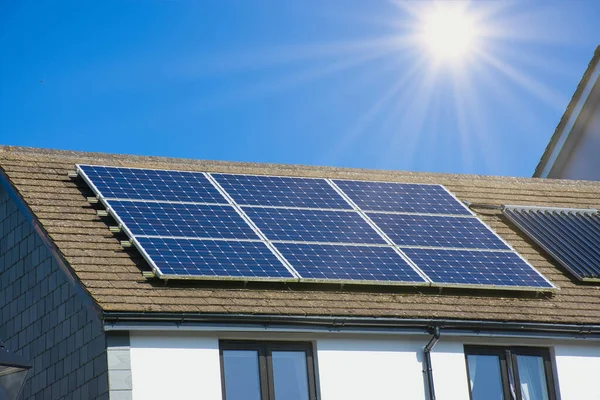 Güneşli bir günde Cornish evinin çatısındaki fotovoltaik elektrik santrali sürdürülebilir kaynakların güneş enerjisi kavramı