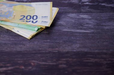 Köşesinde metin ve ahşap arkaplan için fotokopi alanı olan avro banknotları yığını