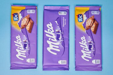 Mavi arka planda üç farklı Milka çikolatası.