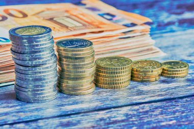 Banknotların önünde farklı yüksekliklerde para yığınları