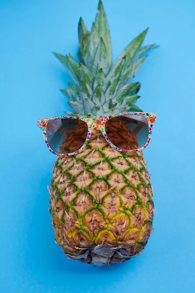 Pineapple with sunglasses against blue background — Stockfoto