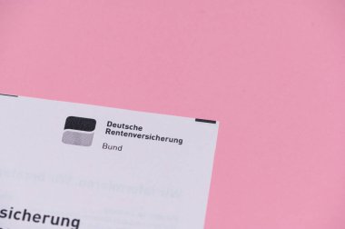 Mainz, Almanya - 27 Ekim 2025: Pembe bir yüzeyde dinlenen Deutsche Rentenversicherung 'dan bir mektup.
