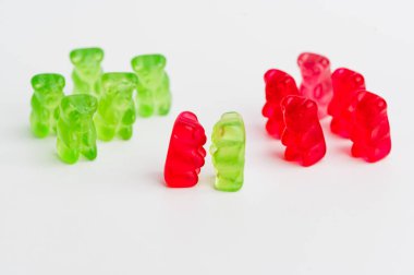 Yeşil ve kırmızı jelibon ayılar beyaz bir yüzeyde gruplandırılır..