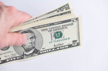 El bir takas için 5 dolarlık banknotlar veriyor.