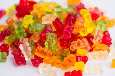 Farklı renklerde jelibon ayılar beyaz bir yüzeye yayılır..