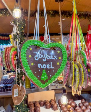 Mainz, Almanya - 19 Aralık 2025: Kalp şeklinde şekerler Mainz 'deki Noel pazarında asılı. Metin Fransızca ve mutlu Noeller demek.