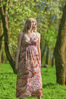 Gülümseyen açık bahar ormandaki şehvetli sarışın kadın portresi