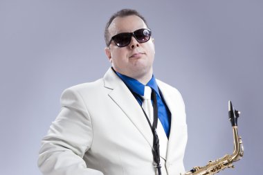 Müzik konsepti ve fikirler. Beyaz Siut Alto Saksafon poz ile yakışıklı beyaz müzisyen