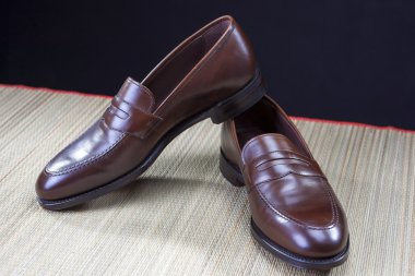 Mens ayakkabı kavramları. Şık kahverengi Penny mokasen ayakkabı saman yüzey üzerine yerleştirilir