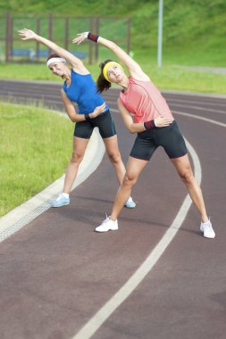Germe egzersizleri açık havada olan iki genç SilenX Sportswomen portresi.