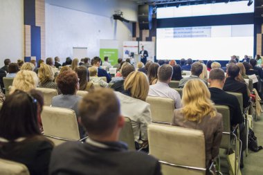 İş fikirleri ve kavramlar. İş adamları kongre salonu büyük sunum ekranda izlerken oturma grubu