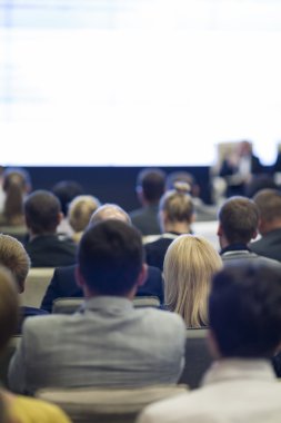 İnsanların önünde sunum ekranda izlerken Konferansı'nda