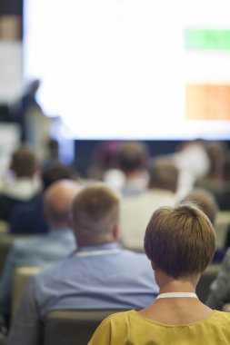 İnsanların önünde sunum ekranda izlerken Konferansı'nda