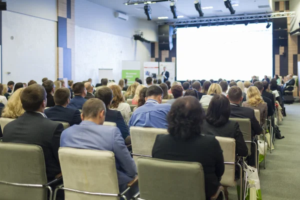 İş fikirleri ve kavramlar. İş adamları kongre salonu büyük sunum ekranda izlerken oturma grubu