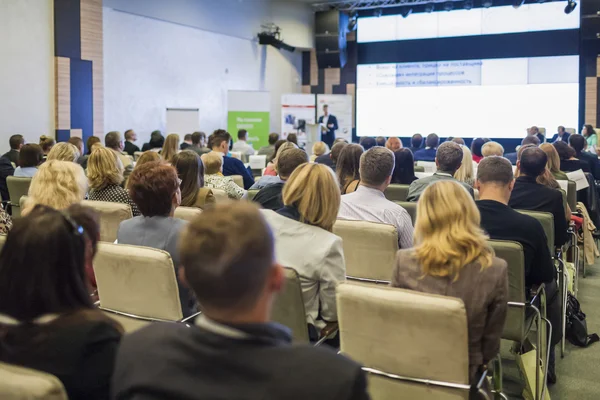 İş fikirleri ve kavramlar. İş adamları kongre salonu büyük sunum ekranda izlerken oturma grubu