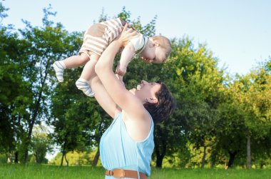 Mutlu anne onunla Park açık havada içinde oynarken onun çocuğu savurma
