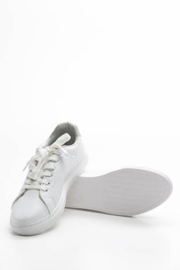 Beyaz arka planda bir çift yeni beyaz spor ayakkabısı. Dikey Resim