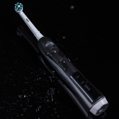 Oral Bakım Konsepti. Profesyonel Elektrikli Diş Fırçası ve Siyah Arkaplan Üzerine Su Sıçratma. Kare Resim