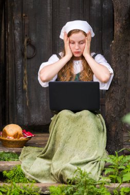 Dışarıdaki Laptop 'la Şaşırmış Kızıl Saçlı Kız pozu. Dikey Resim