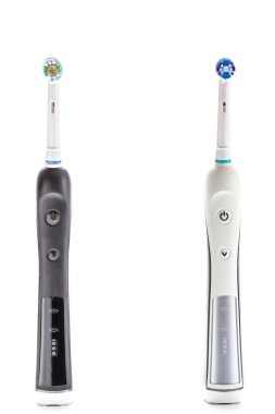 Diş bakımı konseptleri. Beyaz Arkaplanda İki Profesyonel Elektrikli Diş Fırçası Kapanışı. Dikey Resim