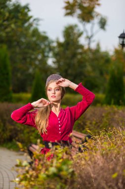 Kırmızı Elbiseli Güzel Uzun Saçlı Beyaz Kız ve Gümüş Diadem Sonbahar Ormanı 'nda Kaldırılmış Ellerle Duruyor. Dikey Resim