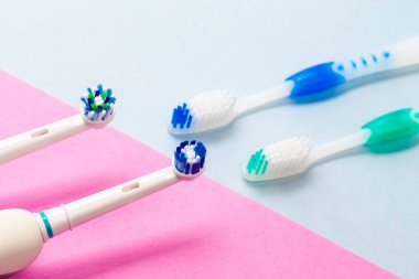 Pembe ve Mavi Arkaplanda Elle Fırçaya Karşı Profesyonel Elektrikli Diş Fırçasının Başları. Yatay Görüntü