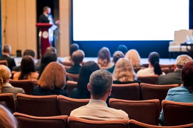 İş adamları konferansta. Erkek Sunucu Salondaki Halk Grubu 'nun önünde konuşuyor. Yatay Resim Kompozisyonu