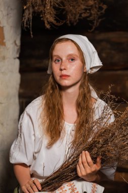 Eski Köy Evi 'nde Heather Buquet ile Rustik Tarz Elbise Poz Veren Beyaz Saçlı Genç Güzel Kız. Dikey Resim