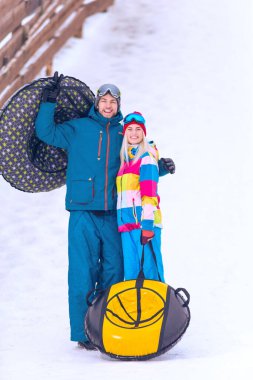 Kış Spor ve Aktiviteleri. Kafkasyalı güzel bir çiftin kışın dağlarda kayak merkezinde metro aktiviteleri yaparken portresi. Dikey Resim