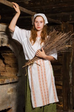 Eski Köy Evi 'nde Heather Buket' le Rustik Tarz Giyimli Güzel Kafkas Saçlı Kız 'ın portresi. Dikey Resim