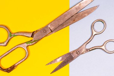 Mavi ve Sarı Kağıt Arkaplan Üzerine yerleştirilmiş Eski Paslı Terzi Makası. Yatay Görüntü