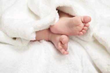 Bebekler ve Yeni Doğanlar Konsepti. Dört haftalık bir bebeğin Macro Yakın plan çekimi. Beyaz Havlunun Üzerinde Ayaklar. Yatay Resim Yönlendirmesi