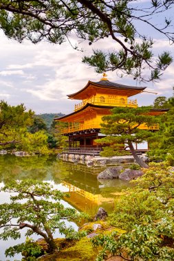 Pond 'lu Kinkaku-Ji Tapınağı ve Kyoto' daki Japon Bahçesi, Altın Saat 'te Japonya' nın ünlü manzarası. Dikey resim