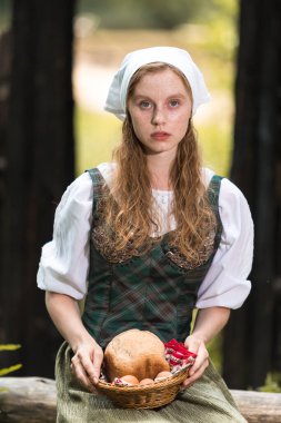 Kafkasya 'nın sakin zencefilli kadın pozu. Village Outdoor' da ev yapımı ekmek sepeti. Dikey Resim Kompozisyonu