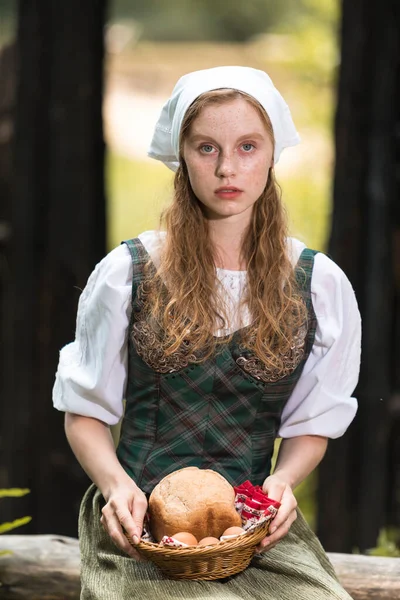 Kafkasya 'nın sakin zencefilli kadın pozu. Village Outdoor' da ev yapımı ekmek sepeti. Dikey Resim Kompozisyonu