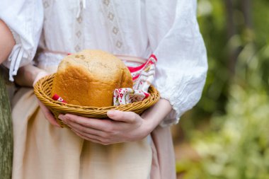 Beyaz Kız 'ın Ev Yapımı Ekmeğini Dışardaki Dekoratif Elbisenin Önünde Basket' te Tutan Makro Çekimi. Yatay Resim Yönlendirmesi