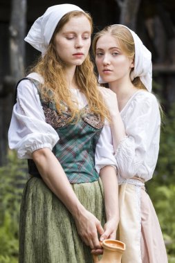 Kırsal Tarz Kavramları. Geleneksel Kırsal Kıyafet Pozisyonunda, Caly Jar ve Birlikte Ekmek Yiyen İki Güzel Beyaz Kız Arkadaş. Dikey Resim